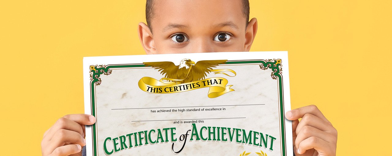 A child proudly holding a certificate of achievement